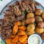 whole30 pot roast on a large plate with carrots and potatoes