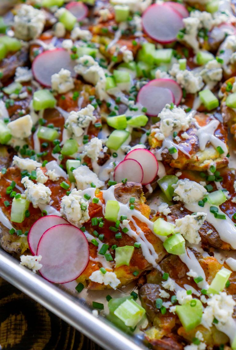 close up photo of crispy smashed potatoes loaded nachos