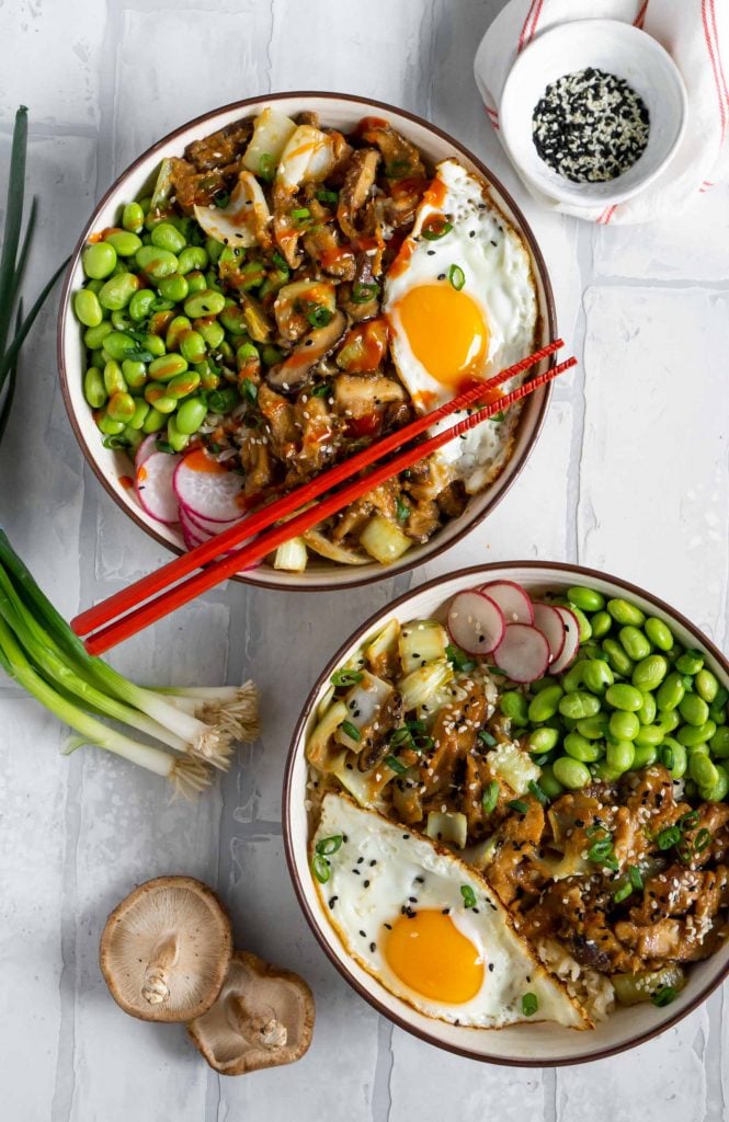 two maple miso mushroom bowls with green onions, shiitake mushrooms, and a bowl of sesame seeds