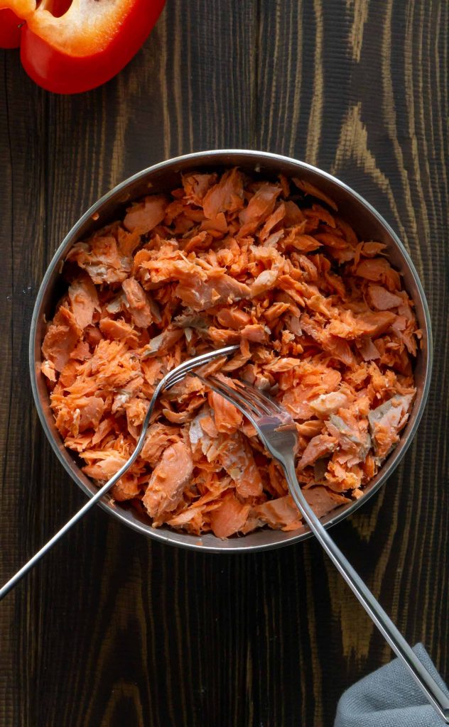 shredded salmon in a metal bowl with two forks