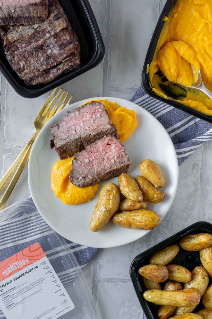 a la carte territory with steak, butternut squash mash, and potatoes on a white plate