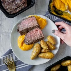 steak, butternut squash mash, and potatoes on a white plate