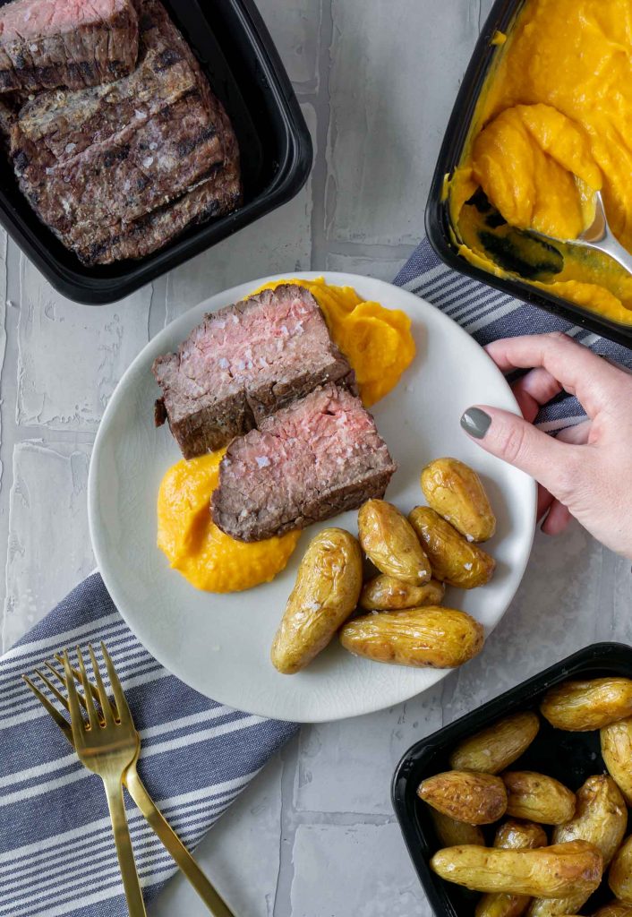 steak, butternut squash mash, and potatoes on a white plate