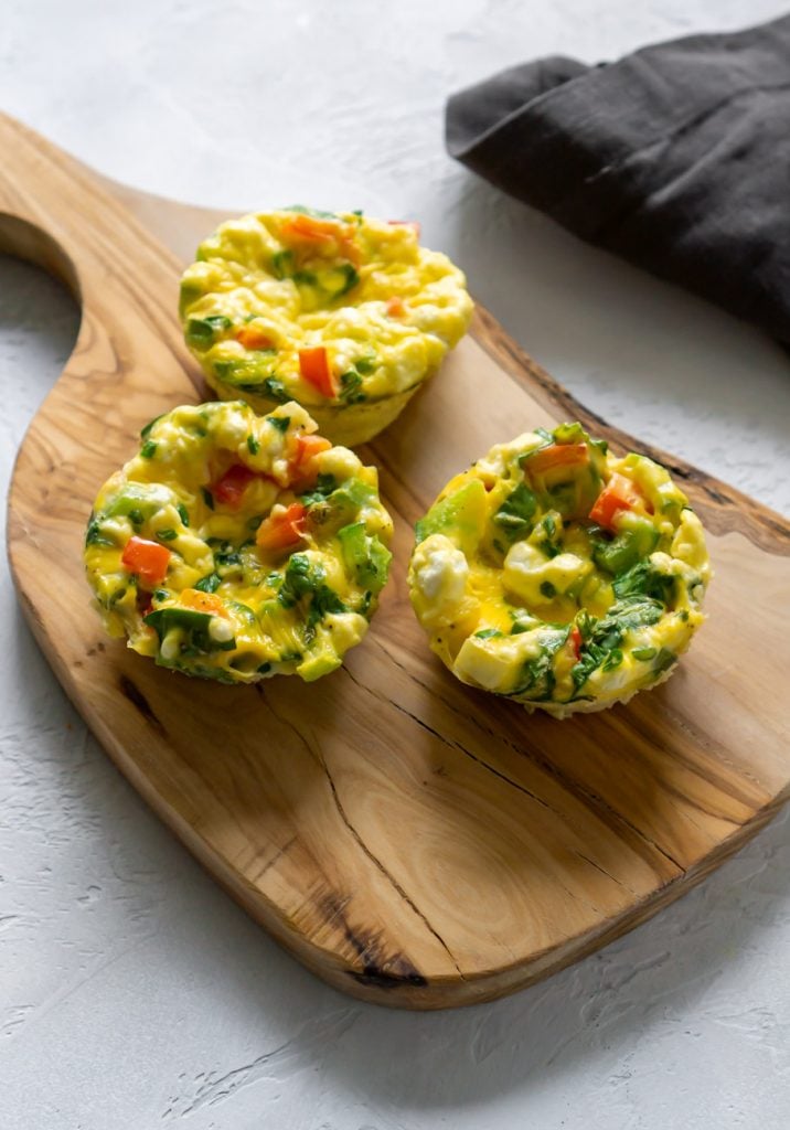3 egg frittata muffins on a wooden serving board