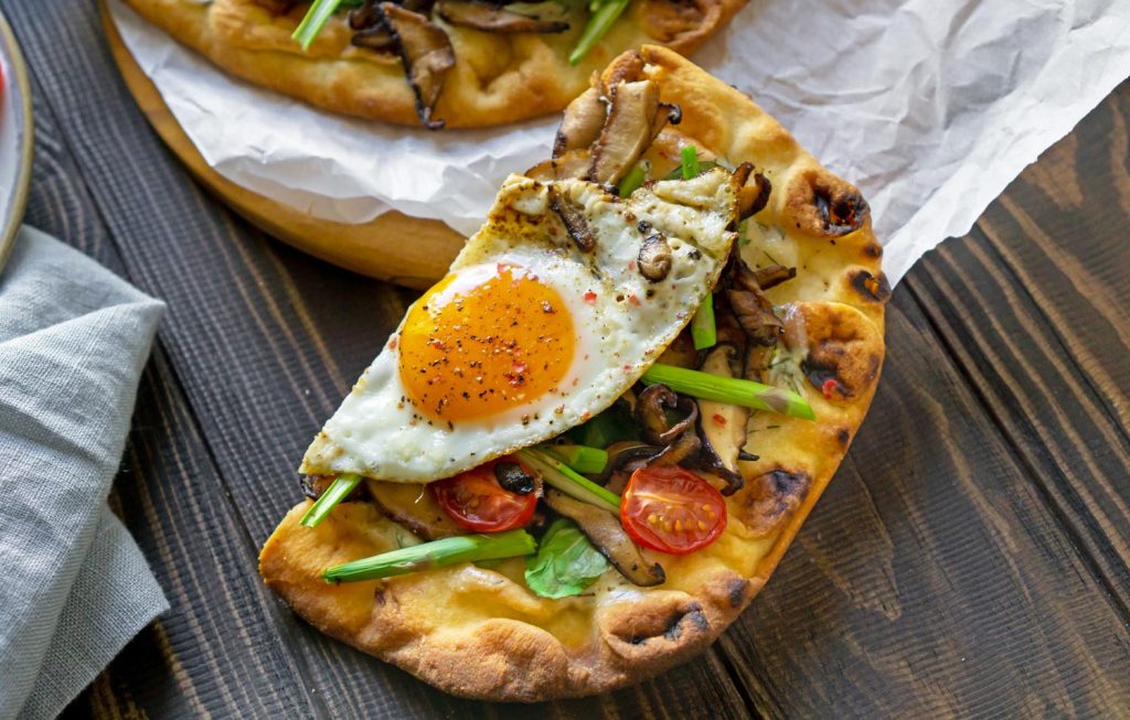 a slice of pizza with an egg on it
