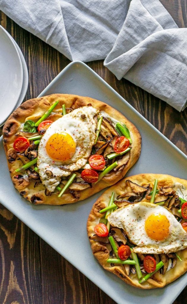 two veggie breakfast pizzas on a blue plate