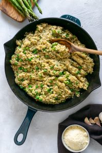 risotto in a large skillet with wooden spoon