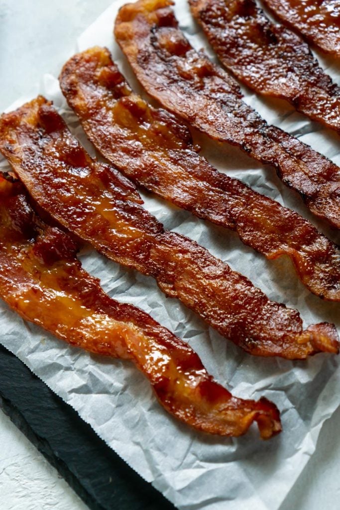candied bacon on white parchment paper