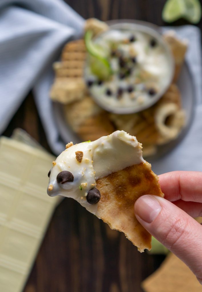 cannoli dip on a waffle cone chip in a hand