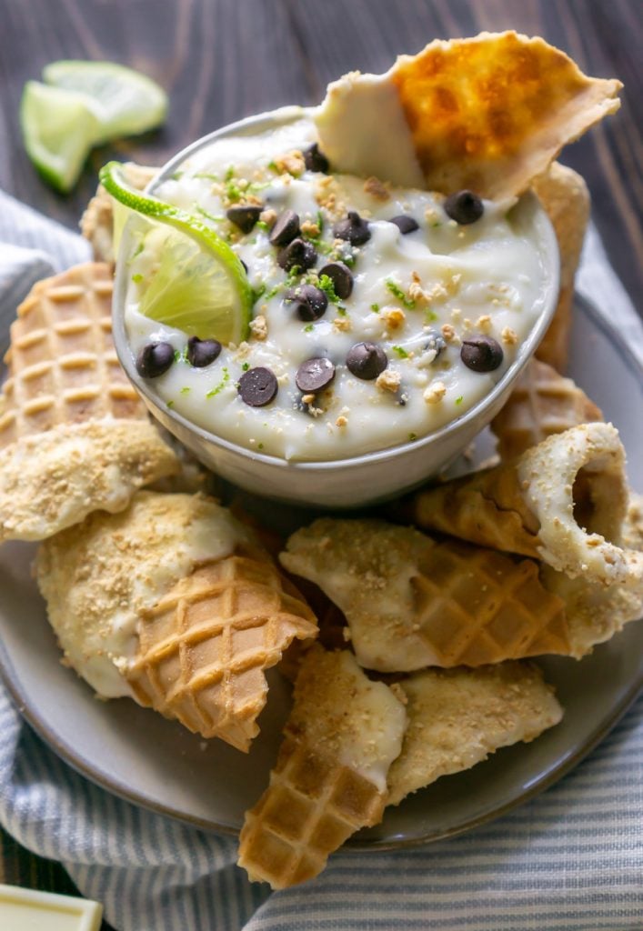 cannoli dip with lime wedges and a waffle cone chip dipping