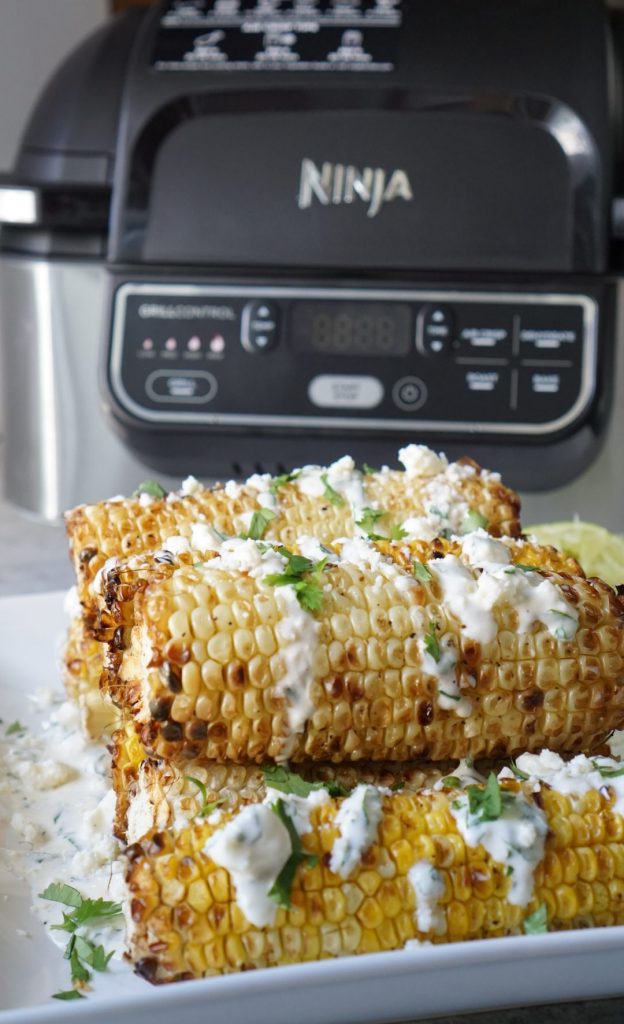 corn on a white plate and an air fryer