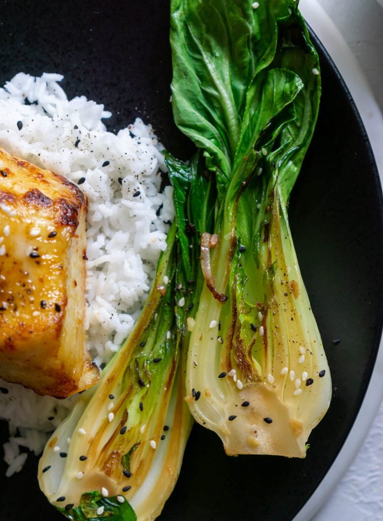 bok choy on a black plate with white rice