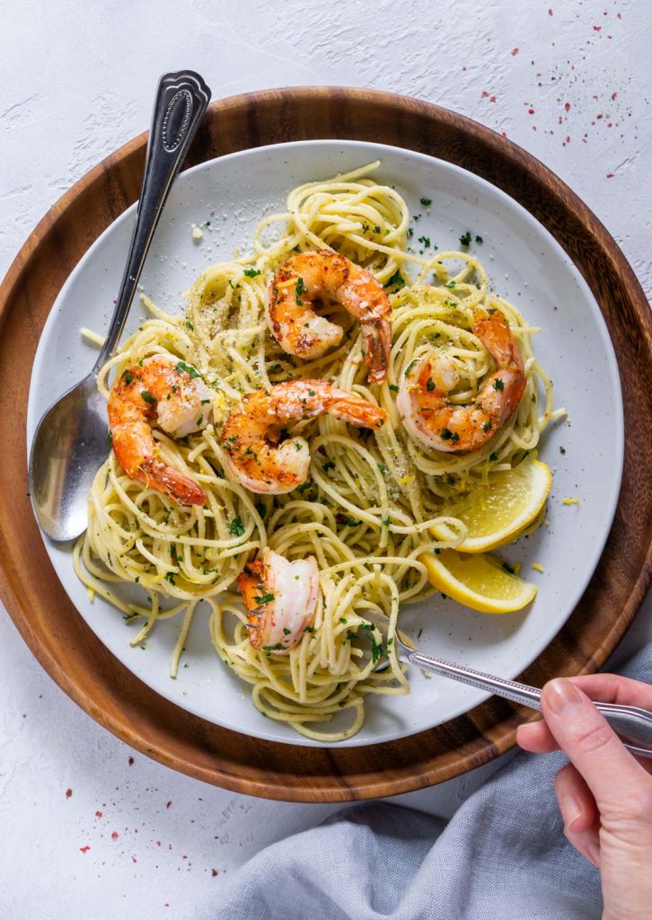 hand holding a fork with a bite of pea pasta