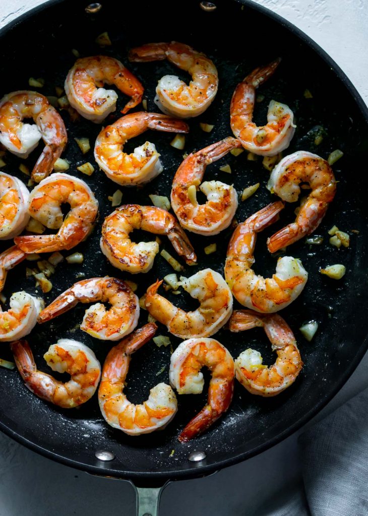 garlic butter shrimp in a large black pan