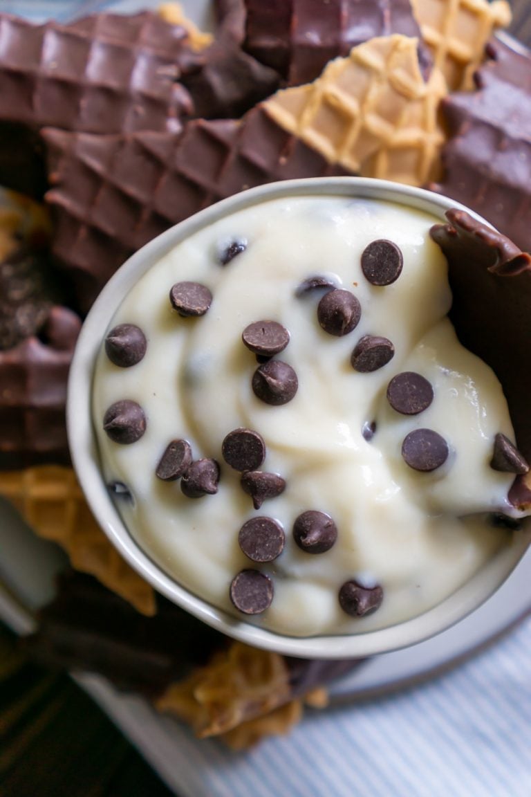 close up of cannoli dip in a small bowl with chocolate chips