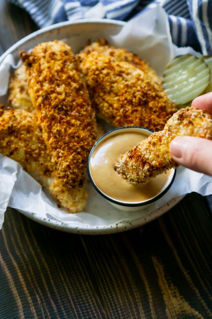 dipping chicken tenders into sauce