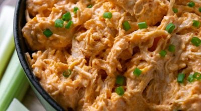 slow cooker buffalo chicken dip in a black bowl
