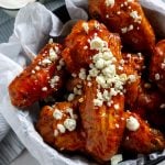air fryer buffalo wings in a bowl with blue cheese crumbles