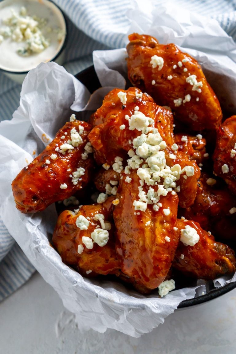 air fryer buffalo wings in a bowl with blue cheese crumbles