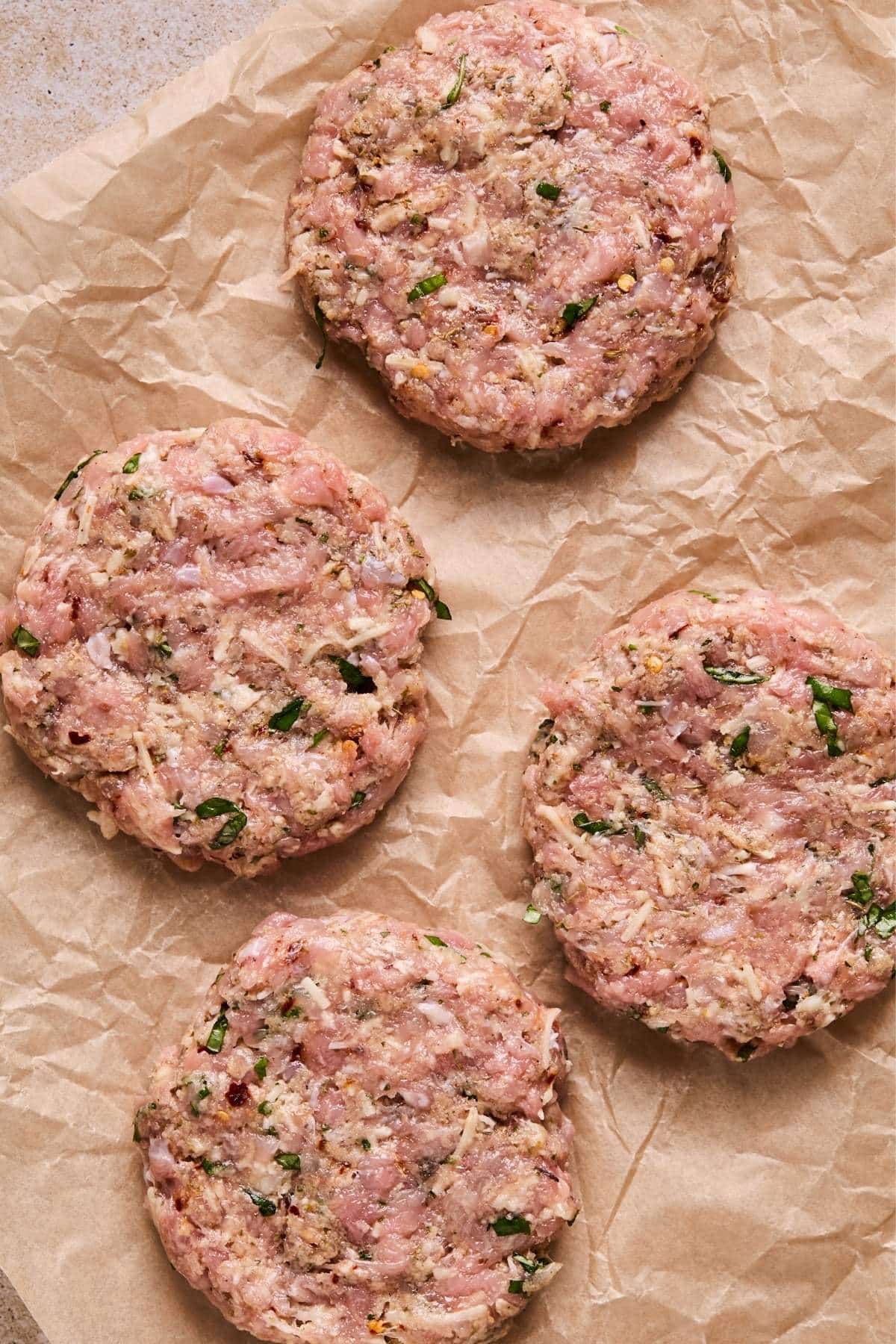 Formed chicken patties on parchment paper.