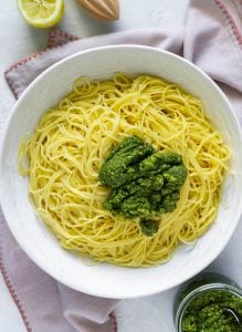 spaghetti in a large white bowl with mint pesto