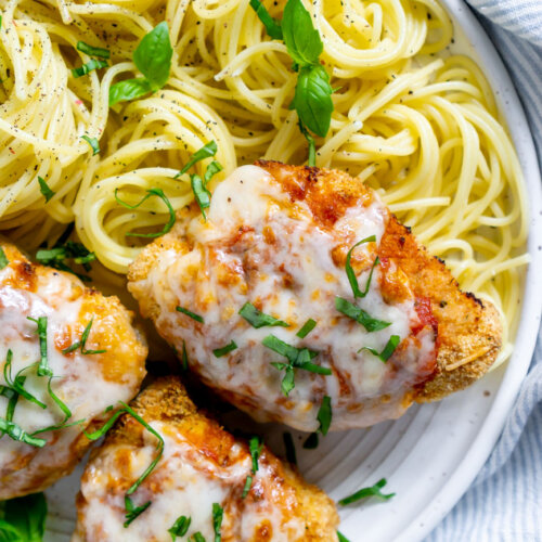 air fryer chicken parmesan on a white plate with spaghetti