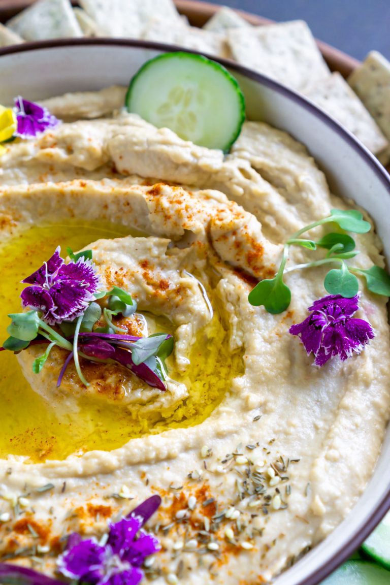 homemade hummus in a bowl with cucumber