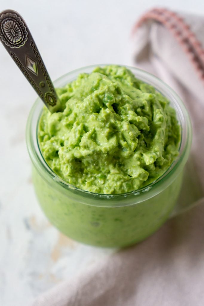pea pesto in a jar with a spoon