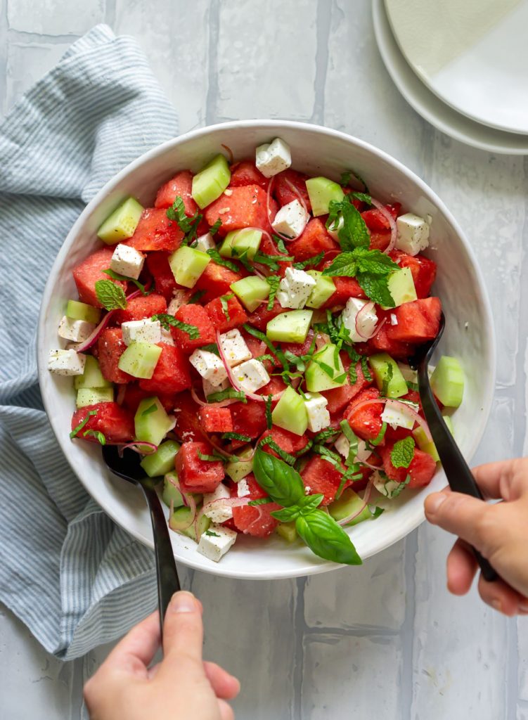 tossing the watermelon salad
