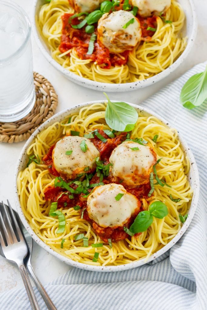 two plates with spaghetti and chicken meatballs