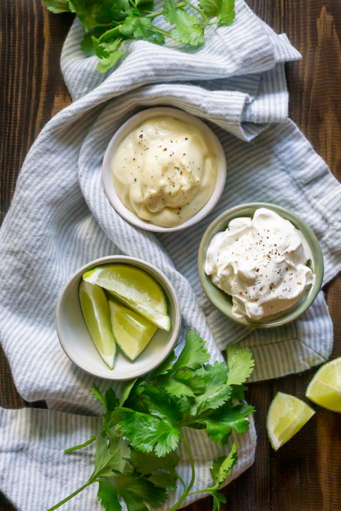 sour cream, mayonnaise, and limes in small bowls