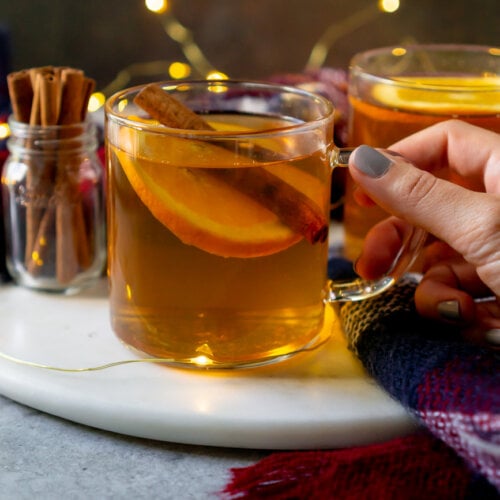 hot toddy in a glass mug with cinnamon sticks