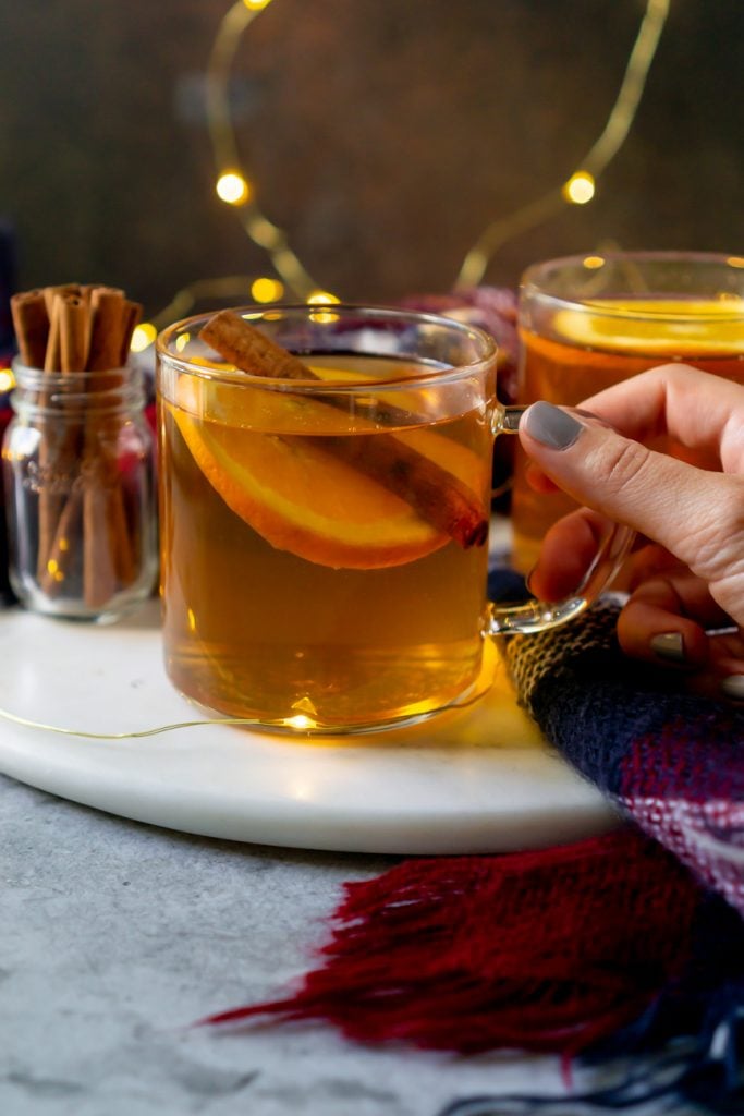 hot toddy in a glass mug with cinnamon sticks