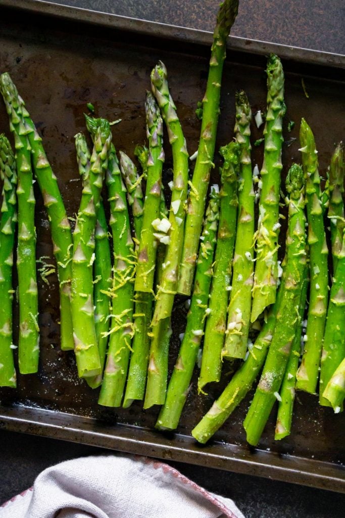 seasoned asparagus on a baking sheet