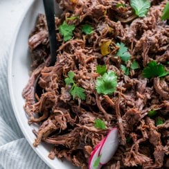 chipotle barbacoa in a white bowl with a black spoon