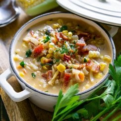corn chowder in a white bowl with parsley