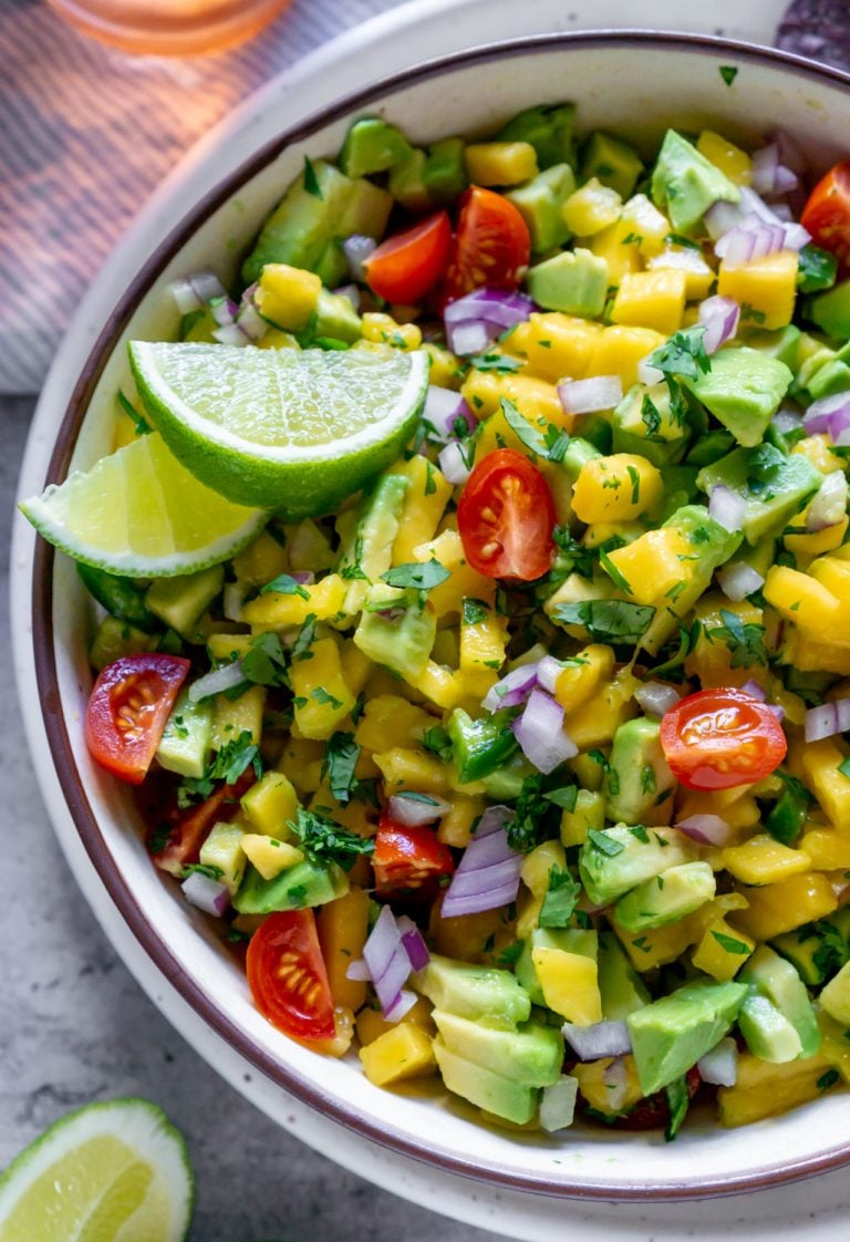 mango salsa in a bowl with lime wedges