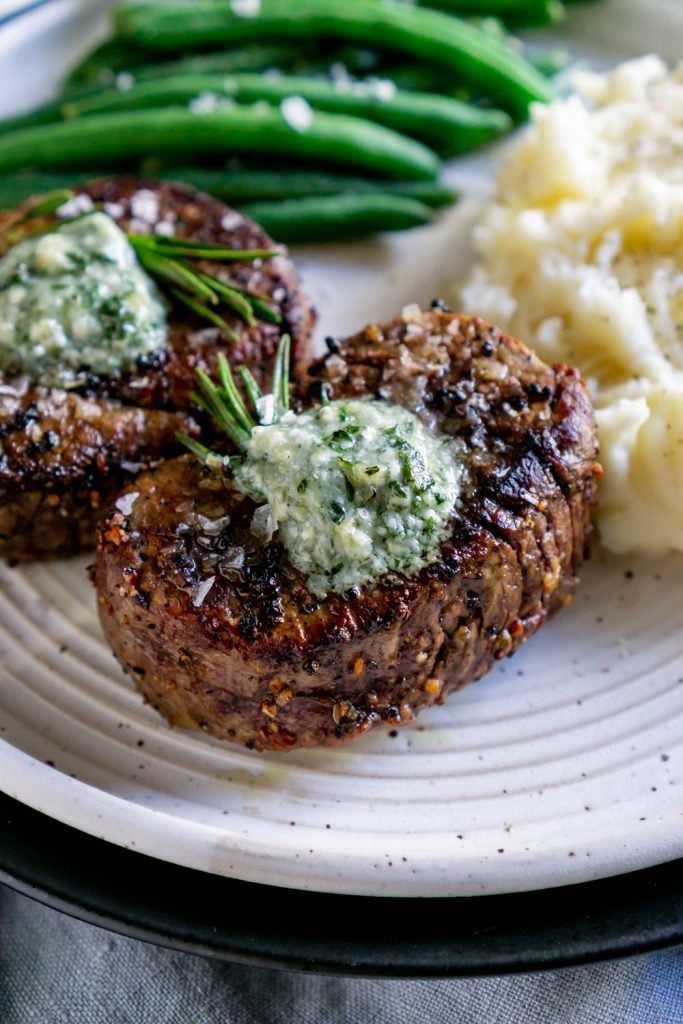 filet mignon on a plate with blue cheese butter