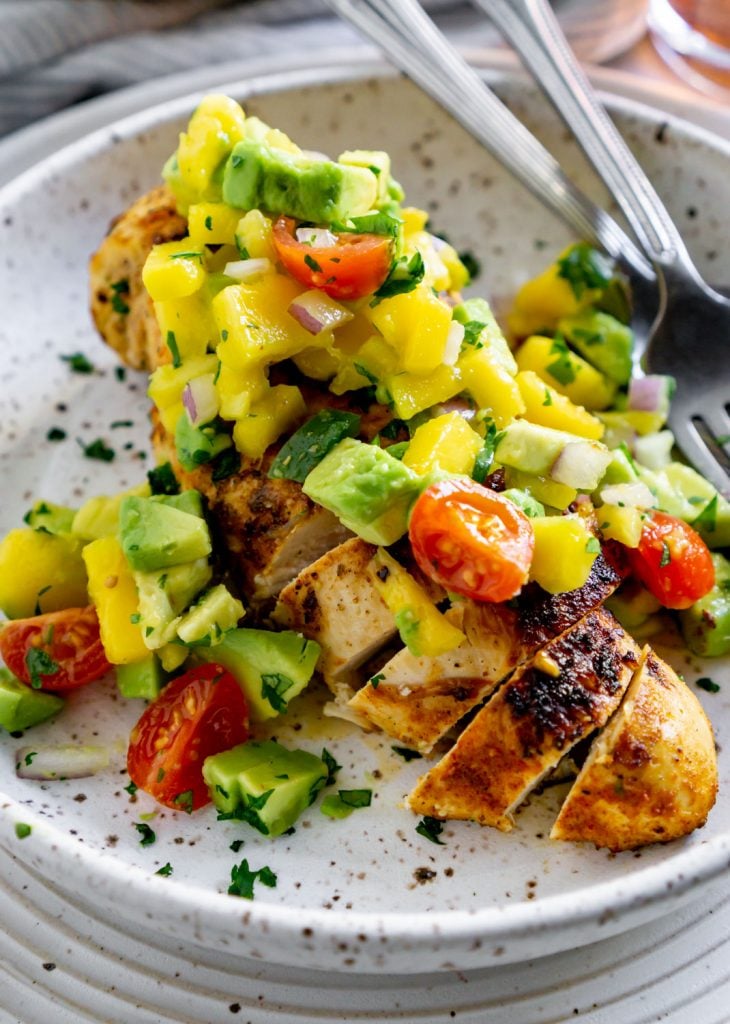 pan seared chicken with mango salsa in a white dish