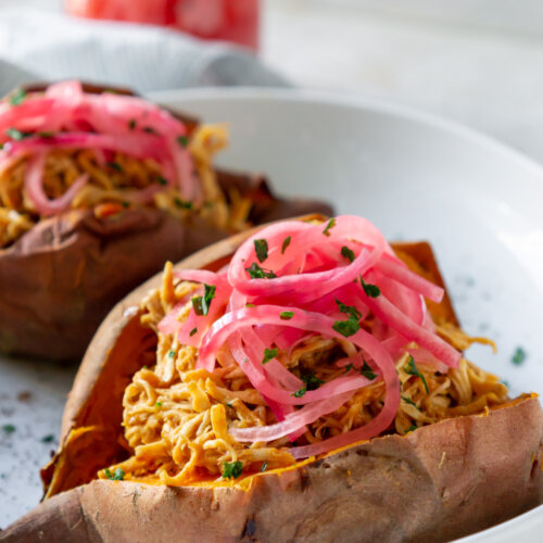 bbq chicken stuffed sweet potato on a white plate