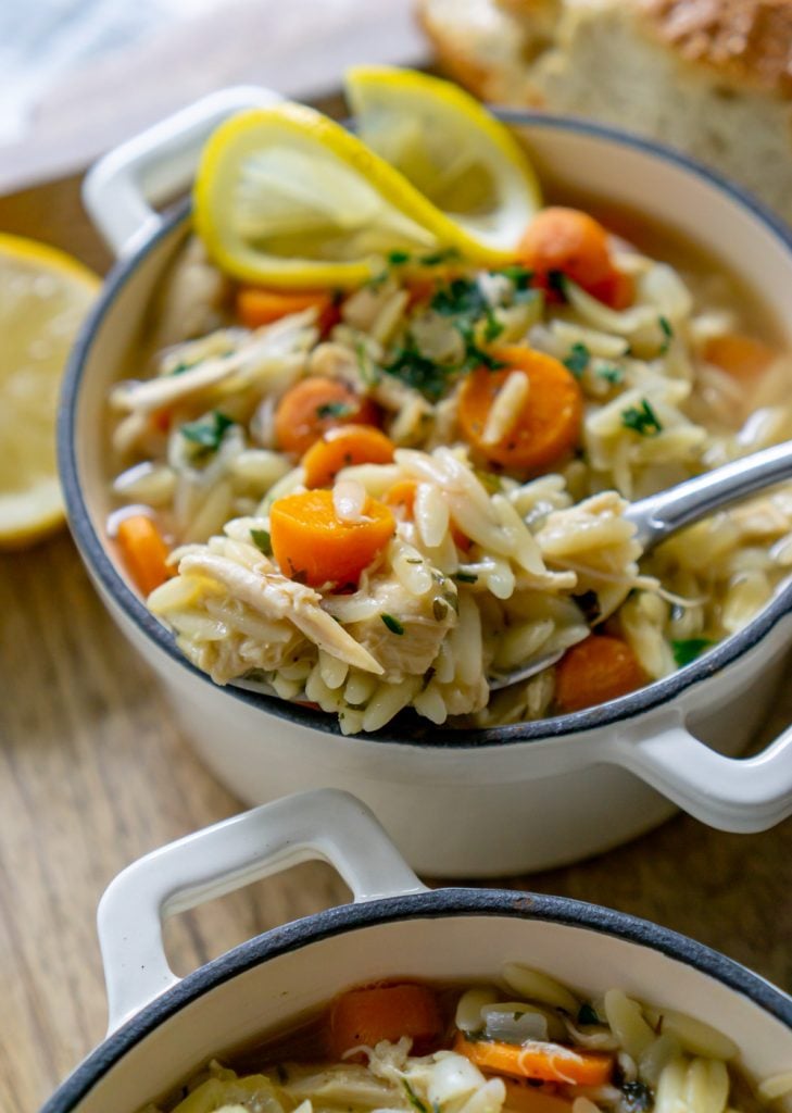 lemon orzo chicken soup in a bowl with a silver spoon