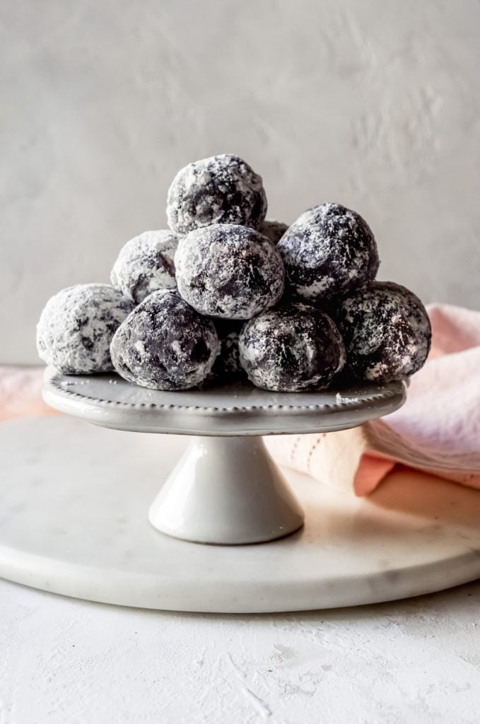 oreo cookie balls on a white cake stand and pink napkin