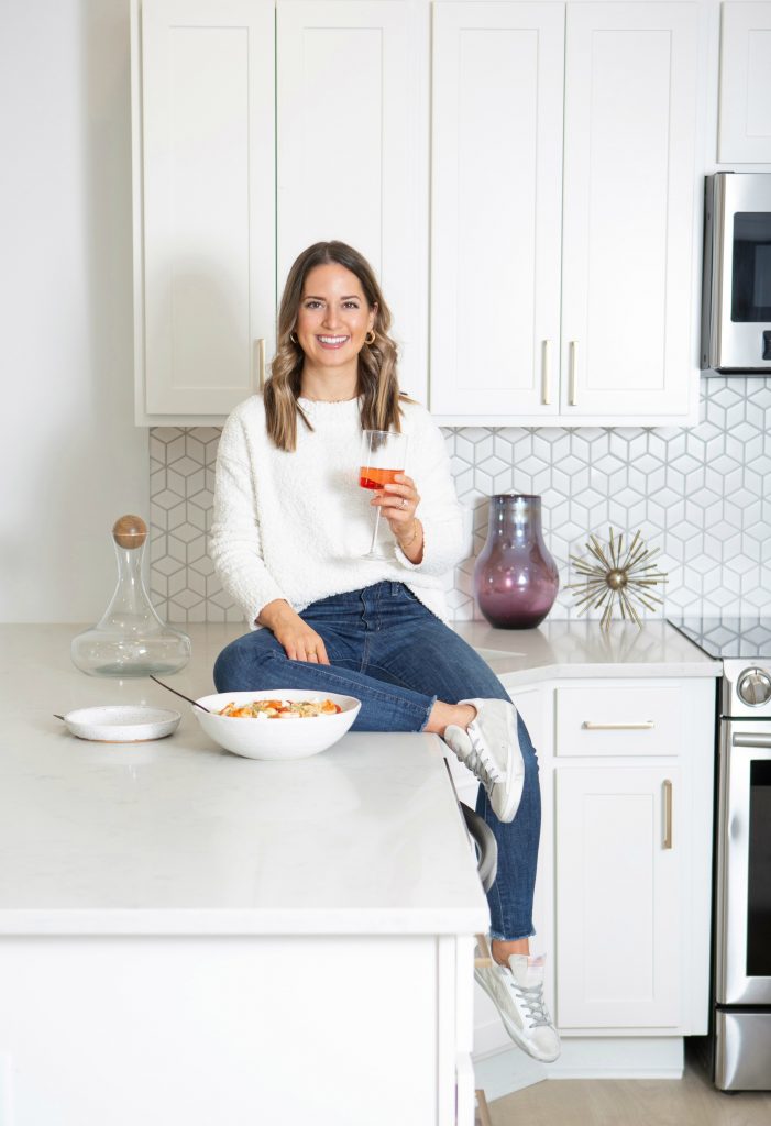 me sitting on a counter in a white kitchen