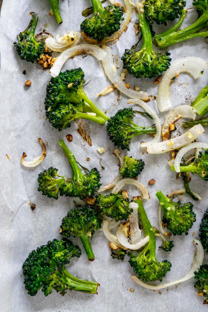 roasted broccolini and onions on parchment paper