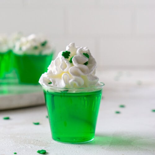 a green vodka jello shot with clover sprinkles