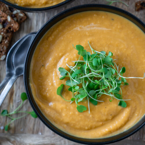 roasted butternut squash soup in bowls on a tray with crackers