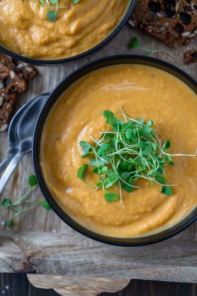 roasted butternut squash soup in bowls on a tray with crackers