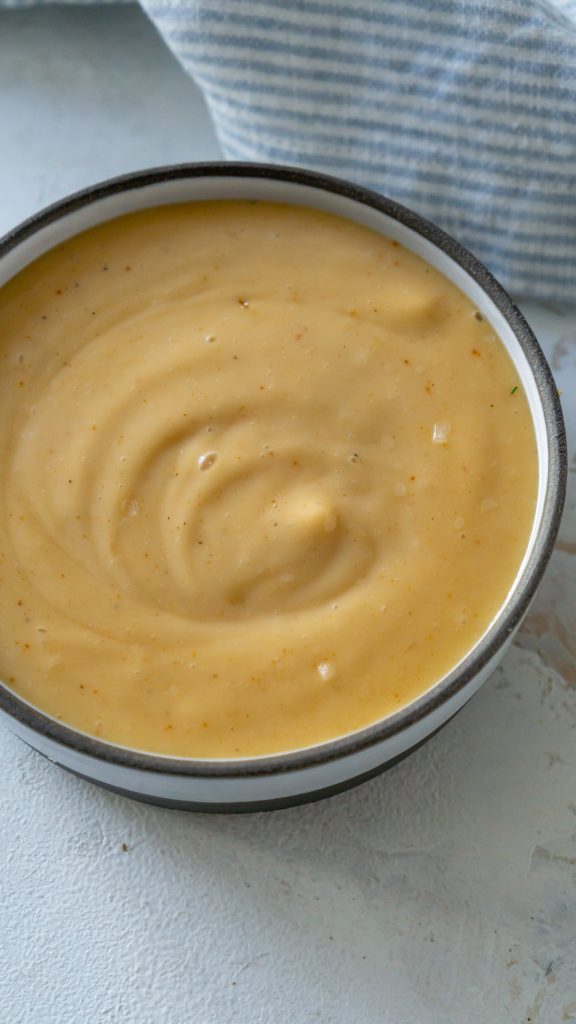 spicy mayo in a small bowl with a blue napkin