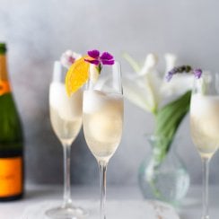 2 champagne cocktails on a white serving tray