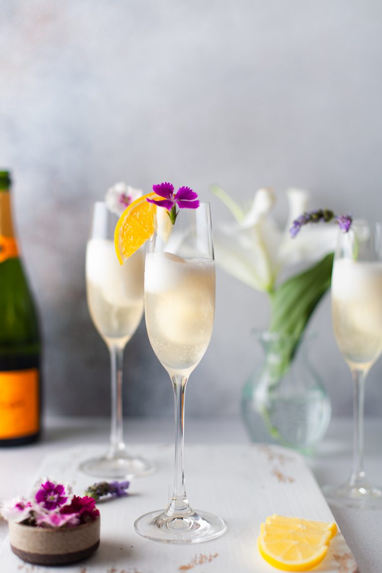 2 champagne cocktails on a white serving tray